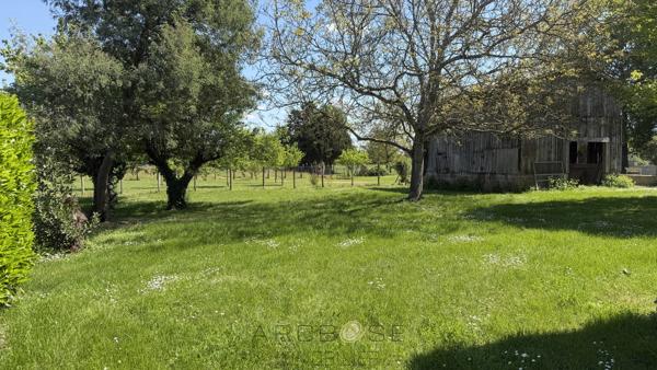 Maison de maître en pierre avec dépendances et jardin clos arboré.