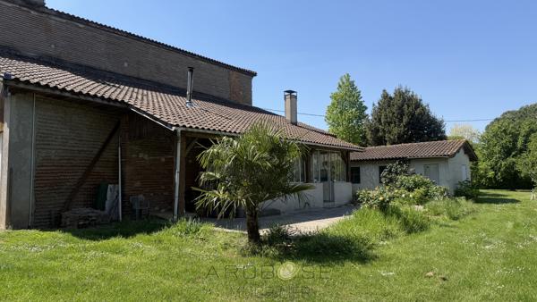 Maison de maître en pierre avec dépendances et jardin clos arboré.