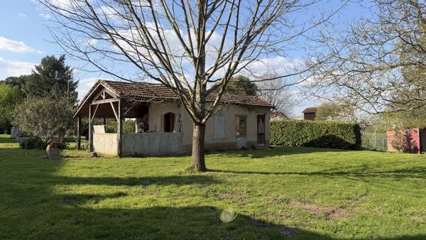 Maison de maître en pierre avec dépendances et jardin clos arboré.