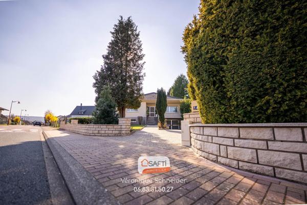 jolie maison implantée sur un grand terrain arboré et clôturé.