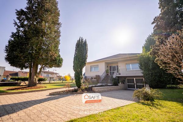 jolie maison implantée sur un grand terrain arboré et clôturé.