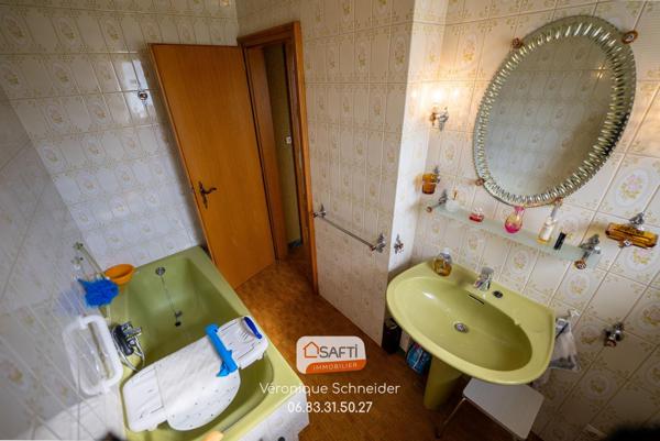 jolie maison implantée sur un grand terrain arboré et clôturé.