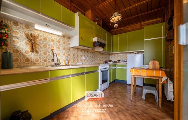 jolie maison implantée sur un grand terrain arboré et clôturé.