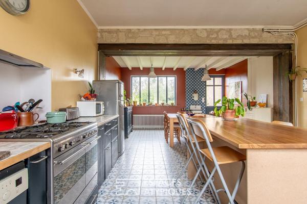 Maison de caractère avec grange et jardin arboré en coeur de village.