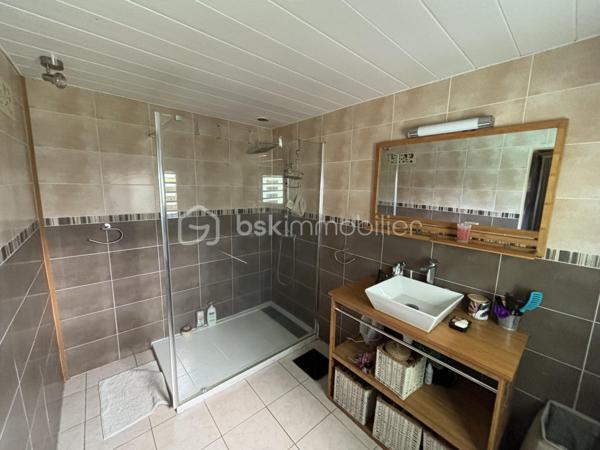 BSK Immobilier vous présente cette superbe maison créole de 138 m² habitables, édifiée sur un terrain clos, arboré et paysager de presque 600 m².
Dès l’entrée, vous serez séduit par ses beaux volumes et son ambiance chaleureuse. La pièce de vie, avec sa belle hauteur sous plafond, s’ouvre sur une cuisine entièrement équipée et aménagée. La maison dispose de 5 chambres, dont une suite parentale avec baignoire à remous, ainsi qu’un grand bureau. Elle comprend également une seconde salle d'eau, un second WC et deux greniers offrant de belles possibilités de rangement.
À l’extérieur, tout a été pensé pour profiter pleinement des lieux. Vous disposerez de deux grandes varangues d’environ 40 m² chacune, dont l’une aménagée avec bar, salon d’extérieur, grande table à manger et jacuzzi, avec vue sur la piscine. La seconde varangue, ainsi que la terrasse, prolongent agréablement les espaces de vie vers un extérieur dédié aux enfants avec trampoline.

Les prestations incluent également :
    - Piscine au sel chauffée
   -  Jacuzzi
   -  Portail électrique
    - Stationnement pour 3 véhicules
    - Deux greniers

La maison bénéficie d’un emplacement pratique et recherché, à seulement :
    - 4 minutes de la 4 voies
   -  10 minutes du front de mer de Saint-Pierre
    - moins de 100 mètres d’une école, d’une épicerie et d’une médiathèque

Un bien rare, alliant confort, élégance et qualité de vie. Il conviendra aussi bien à une famille qu’à un investisseur dans le cadre d’un projet de colocation.
