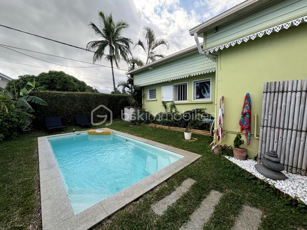 BSK Immobilier vous présente cette superbe maison créole de 138 m² habitables, édifiée sur un terrain clos, arboré et paysager de presque 600 m².
Dès l’entrée, vous serez séduit par ses beaux volumes et son ambiance chaleureuse. La pièce de vie, avec sa belle hauteur sous plafond, s’ouvre sur une cuisine entièrement équipée et aménagée. La maison dispose de 5 chambres, dont une suite parentale avec baignoire à remous, ainsi qu’un grand bureau. Elle comprend également une seconde salle d'eau, un second WC et deux greniers offrant de belles possibilités de rangement.
À l’extérieur, tout a été pensé pour profiter pleinement des lieux. Vous disposerez de deux grandes varangues d’environ 40 m² chacune, dont l’une aménagée avec bar, salon d’extérieur, grande table à manger et jacuzzi, avec vue sur la piscine. La seconde varangue, ainsi que la terrasse, prolongent agréablement les espaces de vie vers un extérieur dédié aux enfants avec trampoline.

Les prestations incluent également :
    - Piscine au sel chauffée
   -  Jacuzzi
   -  Portail électrique
    - Stationnement pour 3 véhicules
    - Deux greniers

La maison bénéficie d’un emplacement pratique et recherché, à seulement :
    - 4 minutes de la 4 voies
   -  10 minutes du front de mer de Saint-Pierre
    - moins de 100 mètres d’une école, d’une épicerie et d’une médiathèque

Un bien rare, alliant confort, élégance et qualité de vie. Il conviendra aussi bien à une famille qu’à un investisseur dans le cadre d’un projet de colocation.