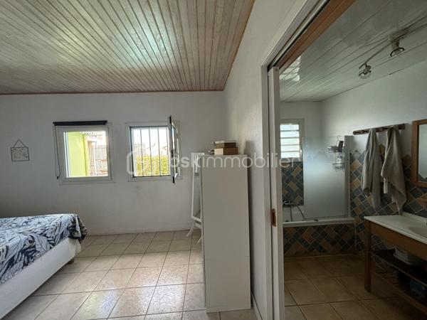 BSK Immobilier vous présente cette superbe maison créole de 138 m² habitables, édifiée sur un terrain clos, arboré et paysager de presque 600 m².
Dès l’entrée, vous serez séduit par ses beaux volumes et son ambiance chaleureuse. La pièce de vie, avec sa belle hauteur sous plafond, s’ouvre sur une cuisine entièrement équipée et aménagée. La maison dispose de 5 chambres, dont une suite parentale avec baignoire à remous, ainsi qu’un grand bureau. Elle comprend également une seconde salle d'eau, un second WC et deux greniers offrant de belles possibilités de rangement.
À l’extérieur, tout a été pensé pour profiter pleinement des lieux. Vous disposerez de deux grandes varangues d’environ 40 m² chacune, dont l’une aménagée avec bar, salon d’extérieur, grande table à manger et jacuzzi, avec vue sur la piscine. La seconde varangue, ainsi que la terrasse, prolongent agréablement les espaces de vie vers un extérieur dédié aux enfants avec trampoline.

Les prestations incluent également :
    - Piscine au sel chauffée
   -  Jacuzzi
   -  Portail électrique
    - Stationnement pour 3 véhicules
    - Deux greniers

La maison bénéficie d’un emplacement pratique et recherché, à seulement :
    - 4 minutes de la 4 voies
   -  10 minutes du front de mer de Saint-Pierre
    - moins de 100 mètres d’une école, d’une épicerie et d’une médiathèque

Un bien rare, alliant confort, élégance et qualité de vie. Il conviendra aussi bien à une famille qu’à un investisseur dans le cadre d’un projet de colocation.