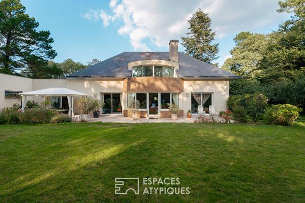 Maison d’Architecte avec jardin paysager dans un environnement boisé.