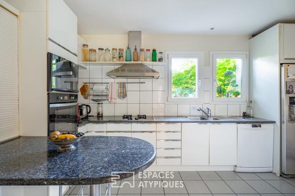 Maison d’Architecte avec jardin paysager dans un environnement boisé.