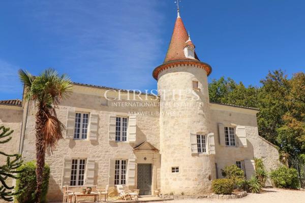 Château avec une tour et une maison d’ami, entouré de jardins faciles à entretenir