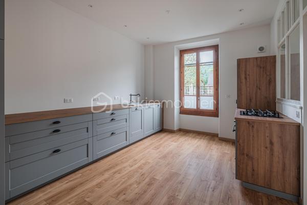 À quelques pas du centre-ville d’Aix-les-Bains et de la gare, dans un environnement recherché pour son calme et sa qualité de vie, découvrez ce superbe appartement haussmannien rénové de 82 m² situé au 1er étage d’un élégant immeuble bourgeois.

Dès l’entrée, le charme opère immédiatement. Parquet bois, moulures d’époque, belle hauteur sous plafond et volumes généreux confèrent à l’appartement une atmosphère chaleureuse et raffinée, idéale pour les amateurs de biens de caractère.
La pièce de vie, baignée de lumière grâce à son exposition Ouest, offre un espace convivial et élégant où la cuisine équipée s’intègre parfaitement grâce à une magnifique verrière atelier, apportant une touche contemporaine au cachet de l’ancien.

L’appartement propose deux chambres spacieuses et confortables, parfaites pour un couple, une petite famille ou un espace bureau pour le télétravail. Une salle de bains avec baignoire ainsi qu’un WC.

Deux balcons viennent renforcer le caractère rare et authentique du bien, tandis qu’une cave et un grenier apportent un confort de rangement appréciable au quotidien.
Entièrement rénové, l’appartement permet de profiter immédiatement d’un cadre de vie élégant et fonctionnel. La future réfection complète de la toiture, déjà votée par la copropriété, constitue également un véritable avantage patrimonial pour les futurs propriétaires.

Vous profiterez d’un emplacement particulièrement apprécié, offrant l’équilibre parfait entre vie citadine, accessibilité et tranquillité, à proximité immédiate des commerces, transports, restaurants et commodités d’Aix-les-Bains.

Chauffage gaz collectif inclus dans les charges de copropriété.
Un appartement lumineux, élégant et plein de charme, idéal pour ceux qui recherchent un bien de caractère dans l’un des secteurs les plus agréables d’Aix-les-Bains.