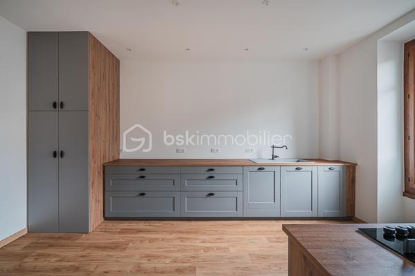 À quelques pas du centre-ville d’Aix-les-Bains et de la gare, dans un environnement recherché pour son calme et sa qualité de vie, découvrez ce superbe appartement haussmannien rénové de 82 m² situé au 1er étage d’un élégant immeuble bourgeois.

Dès l’entrée, le charme opère immédiatement. Parquet bois, moulures d’époque, belle hauteur sous plafond et volumes généreux confèrent à l’appartement une atmosphère chaleureuse et raffinée, idéale pour les amateurs de biens de caractère.
La pièce de vie, baignée de lumière grâce à son exposition Ouest, offre un espace convivial et élégant où la cuisine équipée s’intègre parfaitement grâce à une magnifique verrière atelier, apportant une touche contemporaine au cachet de l’ancien.

L’appartement propose deux chambres spacieuses et confortables, parfaites pour un couple, une petite famille ou un espace bureau pour le télétravail. Une salle de bains avec baignoire ainsi qu’un WC.

Deux balcons viennent renforcer le caractère rare et authentique du bien, tandis qu’une cave et un grenier apportent un confort de rangement appréciable au quotidien.
Entièrement rénové, l’appartement permet de profiter immédiatement d’un cadre de vie élégant et fonctionnel. La future réfection complète de la toiture, déjà votée par la copropriété, constitue également un véritable avantage patrimonial pour les futurs propriétaires.

Vous profiterez d’un emplacement particulièrement apprécié, offrant l’équilibre parfait entre vie citadine, accessibilité et tranquillité, à proximité immédiate des commerces, transports, restaurants et commodités d’Aix-les-Bains.

Chauffage gaz collectif inclus dans les charges de copropriété.
Un appartement lumineux, élégant et plein de charme, idéal pour ceux qui recherchent un bien de caractère dans l’un des secteurs les plus agréables d’Aix-les-Bains.