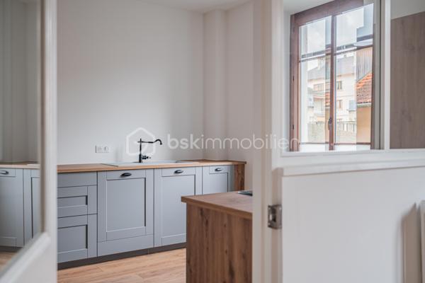 À quelques pas du centre-ville d’Aix-les-Bains et de la gare, dans un environnement recherché pour son calme et sa qualité de vie, découvrez ce superbe appartement haussmannien rénové de 82 m² situé au 1er étage d’un élégant immeuble bourgeois.

Dès l’entrée, le charme opère immédiatement. Parquet bois, moulures d’époque, belle hauteur sous plafond et volumes généreux confèrent à l’appartement une atmosphère chaleureuse et raffinée, idéale pour les amateurs de biens de caractère.
La pièce de vie, baignée de lumière grâce à son exposition Ouest, offre un espace convivial et élégant où la cuisine équipée s’intègre parfaitement grâce à une magnifique verrière atelier, apportant une touche contemporaine au cachet de l’ancien.

L’appartement propose deux chambres spacieuses et confortables, parfaites pour un couple, une petite famille ou un espace bureau pour le télétravail. Une salle de bains avec baignoire ainsi qu’un WC.

Deux balcons viennent renforcer le caractère rare et authentique du bien, tandis qu’une cave et un grenier apportent un confort de rangement appréciable au quotidien.
Entièrement rénové, l’appartement permet de profiter immédiatement d’un cadre de vie élégant et fonctionnel. La future réfection complète de la toiture, déjà votée par la copropriété, constitue également un véritable avantage patrimonial pour les futurs propriétaires.

Vous profiterez d’un emplacement particulièrement apprécié, offrant l’équilibre parfait entre vie citadine, accessibilité et tranquillité, à proximité immédiate des commerces, transports, restaurants et commodités d’Aix-les-Bains.

Chauffage gaz collectif inclus dans les charges de copropriété.
Un appartement lumineux, élégant et plein de charme, idéal pour ceux qui recherchent un bien de caractère dans l’un des secteurs les plus agréables d’Aix-les-Bains.