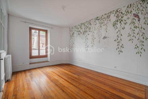 À quelques pas du centre-ville d’Aix-les-Bains et de la gare, dans un environnement recherché pour son calme et sa qualité de vie, découvrez ce superbe appartement haussmannien rénové de 82 m² situé au 1er étage d’un élégant immeuble bourgeois.

Dès l’entrée, le charme opère immédiatement. Parquet bois, moulures d’époque, belle hauteur sous plafond et volumes généreux confèrent à l’appartement une atmosphère chaleureuse et raffinée, idéale pour les amateurs de biens de caractère.
La pièce de vie, baignée de lumière grâce à son exposition Ouest, offre un espace convivial et élégant où la cuisine équipée s’intègre parfaitement grâce à une magnifique verrière atelier, apportant une touche contemporaine au cachet de l’ancien.

L’appartement propose deux chambres spacieuses et confortables, parfaites pour un couple, une petite famille ou un espace bureau pour le télétravail. Une salle de bains avec baignoire ainsi qu’un WC.

Deux balcons viennent renforcer le caractère rare et authentique du bien, tandis qu’une cave et un grenier apportent un confort de rangement appréciable au quotidien.
Entièrement rénové, l’appartement permet de profiter immédiatement d’un cadre de vie élégant et fonctionnel. La future réfection complète de la toiture, déjà votée par la copropriété, constitue également un véritable avantage patrimonial pour les futurs propriétaires.

Vous profiterez d’un emplacement particulièrement apprécié, offrant l’équilibre parfait entre vie citadine, accessibilité et tranquillité, à proximité immédiate des commerces, transports, restaurants et commodités d’Aix-les-Bains.

Chauffage gaz collectif inclus dans les charges de copropriété.
Un appartement lumineux, élégant et plein de charme, idéal pour ceux qui recherchent un bien de caractère dans l’un des secteurs les plus agréables d’Aix-les-Bains.