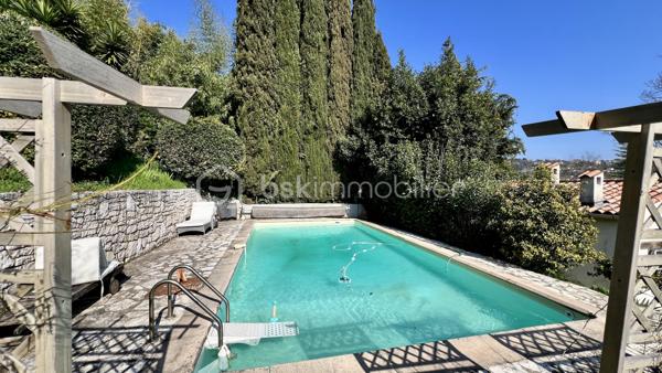Située à La Colle-sur-Loup, à la limite de Cagnes-sur-Mer et Villeneuve-Loubet, à quelques minutes du célèbre village de Saint-Paul-de-Vence, des commerces et des axes principaux, BSK Immobilier vous propose en exclusivité cette villa 7 pièces au fort potentiel, offrant une belle vue dégagée sur les collines et le village.

Exposée Est et Sud, la maison bénéficie d’une luminosité optimale dès le matin et d’un ensoleillement agréable tout au long de la journée.

Développant de beaux volumes, cette villa offre de nombreuses possibilités d’aménagement pour s’adapter à tous les projets : grande maison familiale, résidence secondaire ou encore projet à usage mixte.

À l’étage supérieur, vous découvrirez une entrée, un vaste séjour lumineux avec plafond cathédrale, une cuisine indépendante, deux chambres et une salle de bains.

Le niveau inférieur propose une grande cuisine ouverte sur salle à manger, un espace bibliothèque pouvant faire office de chambre ou bureau, une chambre avec salle de bains ainsi qu’un superbe jardin d’hiver baigné de lumière.

De nombreuses terrasses permettent de profiter pleinement du cadre verdoyant et du climat azuréen.

Côté prestations : climatisation, double vitrage neuf, DPE C et GES A, garantissant confort et efficacité énergétique.

La propriété dispose également d’une maison d’amis indépendante, d’un terrain paysagé agrémenté d’oliviers et d’agrumes, ainsi que d’un environnement entièrement clôturé.

Ce bien s’adresse aussi bien à une famille qu’à un projet intergénérationnel ou à un investissement, dans un secteur recherché entre mer et collines.

Une opportunité rare à découvrir sans tarder.