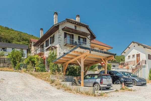 À seulement quelques minutes d'Aix-les-Bains, découvrez cette bâtisse de caractère entièrement rénovée, où le charme de la pierre s'allie au confort d'aujourd'hui.
Située dans un environnement calme, à proximité immédiate de la forêt de Corsuet, elle offre un cadre de vie privilégié entre nature et ville, avec une belle vue dégagée sur le Revard, la Dent du Chat et les montagnes environnantes.

Dès l'entrée, les volumes généreux, les grandes ouvertures et les matériaux authentiques révèlent toute la personnalité de cette maison. Les murs en pierre, les parquets massifs et les belles hauteurs sous plafond confèrent à la maison une atmosphère chaleureuse et authentique.
La maison développe environ 110 m² habitables. Le rez-de-chaussée accueille une vaste pièce de vie d'environ 40 m² avec cuisine ouverte entièrement équipée, une chambre avec salle d'eau privative ainsi qu'un WC indépendant, permettant une vie de plain-pied.

À l'étage, deux belles chambres, une seconde salle d'eau moderne et un WC indépendant composent un espace nuit confortable et fonctionnel.
Entièrement rénovée avec soin, la maison est prête à accueillir ses futurs propriétaires sans travaux importants. Ses épais murs en pierre offrent également un confort très appréciable en été, en conservant naturellement une agréable fraîcheur, même lors des fortes chaleurs.

À l'extérieur, le jardin et les terrasses ombragées invitent à profiter pleinement du cadre environnant et de la vue sur les montagnes. Un carport ainsi que plusieurs places de stationnement complètent les prestations.
Une superbe cave voûtée d'environ 35 m² ainsi que 77 m² de combles aménageables viennent compléter ce bien et offrent un véritable potentiel d'évolution selon vos envies.

À quelques pas des sentiers de randonnée et de VTT de la forêt de Corsuet, et à seulement quelques minutes des commerces, des écoles, du lac du Bourget et des accès autoroutiers, cette maison offre un équilibre rare entre authenticité, confort et qualité de vie.

Ce que vous allez apprécier :
✔ Maison entièrement rénovée, prête à vivre de plain-pied
✔ Pièce de vie de 40 m² + 2 salles d'eau
✔ Cave voûtée de 35 m²
✔ 77 m² de combles aménageables
✔ Vue dégagée sur les montagnes
✔ Fraîcheur naturelle en été grâce aux murs en pierre
✔ Forêt de Corsuet à proximité immédiate
✔ DPE C

Un lieu de vie avant tout
Plus qu'une maison, c'est un lieu de vie. Ici, on profite de la nature sans s'éloigner de la ville, des soirées sur la terrasse face aux montagnes, de la fraîcheur des murs en pierre durant l'été et des départs à pied vers la forêt de Corsuet.
Authentique, chaleureuse et soigneusement rénovée, cette maison séduira celles et ceux qui recherchent autant une qualité de vie qu'un bien de caractère.

Pour plus d'informations ou pour organiser une visite, contactez-moi. Une vidéo de présentation est également disponible sur demande.
