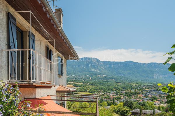 À seulement quelques minutes d'Aix-les-Bains, découvrez cette bâtisse de caractère entièrement rénovée, où le charme de la pierre s'allie au confort d'aujourd'hui.
Située dans un environnement calme, à proximité immédiate de la forêt de Corsuet, elle offre un cadre de vie privilégié entre nature et ville, avec une belle vue dégagée sur le Revard, la Dent du Chat et les montagnes environnantes.

Dès l'entrée, les volumes généreux, les grandes ouvertures et les matériaux authentiques révèlent toute la personnalité de cette maison. Les murs en pierre, les parquets massifs et les belles hauteurs sous plafond confèrent à la maison une atmosphère chaleureuse et authentique.
La maison développe environ 110 m² habitables. Le rez-de-chaussée accueille une vaste pièce de vie d'environ 40 m² avec cuisine ouverte entièrement équipée, une chambre avec salle d'eau privative ainsi qu'un WC indépendant, permettant une vie de plain-pied.

À l'étage, deux belles chambres, une seconde salle d'eau moderne et un WC indépendant composent un espace nuit confortable et fonctionnel.
Entièrement rénovée avec soin, la maison est prête à accueillir ses futurs propriétaires sans travaux importants. Ses épais murs en pierre offrent également un confort très appréciable en été, en conservant naturellement une agréable fraîcheur, même lors des fortes chaleurs.

À l'extérieur, le jardin et les terrasses ombragées invitent à profiter pleinement du cadre environnant et de la vue sur les montagnes. Un carport ainsi que plusieurs places de stationnement complètent les prestations.
Une superbe cave voûtée d'environ 35 m² ainsi que 77 m² de combles aménageables viennent compléter ce bien et offrent un véritable potentiel d'évolution selon vos envies.

À quelques pas des sentiers de randonnée et de VTT de la forêt de Corsuet, et à seulement quelques minutes des commerces, des écoles, du lac du Bourget et des accès autoroutiers, cette maison offre un équilibre rare entre authenticité, confort et qualité de vie.

Ce que vous allez apprécier :
✔ Maison entièrement rénovée, prête à vivre de plain-pied
✔ Pièce de vie de 40 m² + 2 salles d'eau
✔ Cave voûtée de 35 m²
✔ 77 m² de combles aménageables
✔ Vue dégagée sur les montagnes
✔ Fraîcheur naturelle en été grâce aux murs en pierre
✔ Forêt de Corsuet à proximité immédiate
✔ DPE C

Un lieu de vie avant tout
Plus qu'une maison, c'est un lieu de vie. Ici, on profite de la nature sans s'éloigner de la ville, des soirées sur la terrasse face aux montagnes, de la fraîcheur des murs en pierre durant l'été et des départs à pied vers la forêt de Corsuet.
Authentique, chaleureuse et soigneusement rénovée, cette maison séduira celles et ceux qui recherchent autant une qualité de vie qu'un bien de caractère.

Pour plus d'informations ou pour organiser une visite, contactez-moi. Une vidéo de présentation est également disponible sur demande.