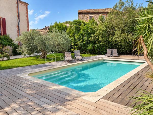 Maison de maître rénovée, cinq suites, piscine, spa et garage 

À Castelnau-d’Aude, cette maison de maître de 1900 conjugue le caractère d’une demeure ancienne et le confort d’une rénovation complète. Acquise en 2016, elle a bénéficié de trois années de travaux, avec une attention particulière portée aux matériaux et à la préservation de son identité.

Sur une parcelle paysagée de 1 035 m², elle développe 353,68 m² habitables, complétés par un garage attenant de 100 m². Grande maison familiale ou habitation avec quatre chambres d’hôtes et un espace privé pour les propriétaires : sa configuration se prête aux deux projets.

Au rez-de-chaussée, la réception de 53 m² séduit par ses grandes ouvertures, ses quatre mètres de hauteur sous plafond et ses carreaux de ciment d’origine. Organisée en deux espaces, elle accueille une cheminée Godin à foyer fermé. Dans son prolongement, la salle à manger de 41 m² offre un cadre généreux pour recevoir, avec ses sols anciens et sa cheminée restaurée.

La cuisine équipée de 28 m² associe un piano de cuisson Godin, de nombreux rangements et des équipements soignés. Elle bénéficie d’une arrière-cuisine de 21 m², en complément de la surface habitable, et d’un accès à la cuisine d’été.

À l’étage, cinq chambres aux ambiances singulières disposent chacune de leur salle d’eau ou salle de bains. À l’écart des autres chambres, l’espace réservé aux propriétaires comprend également une salle de bains séparée et un dressing de plus de 15 m². Parquets massifs, volumes et décoration donnent à chaque chambre sa personnalité.

Le jardin s’organise autour de plusieurs lieux de vie : terrasses, espaces ombragés et plantations méditerranéennes. Oliviers, agrumes et massifs fleuris accompagnent une piscine au sel chauffée de 9 × 5 mètres, bordée d’une terrasse en ipé. Un spa chauffé pour quatre personnes complète cet espace de détente.

La cuisine d’été aménagée sur mesure, avec plan de travail en Dekton, réfrigérateur et lave-vaisselle intégrés, prolonge les moments de convivialité sur une terrasse pouvant accueillir de grandes tablées.

Un garage de 100 m² offrant environ six mètres de hauteur sous plafond, trois places de stationnement et une annexe avec local technique complètent l’ensemble. Le système de chauffage central au fioul a été refait en 2019.

Une demeure pour recevoir famille et amis, ou poursuivre une activité de chambres d’hôtes dans un cadre de caractère.

Prix de vente : 695 000 €, honoraires à la charge du vendeur.