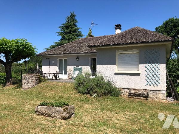 Une maison en pierres, jardin autour avec un abri de jardin et deux garages non attenants.