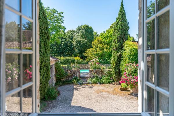 Domaine historique avec piscine, verger et vues sur la campagne environnante.