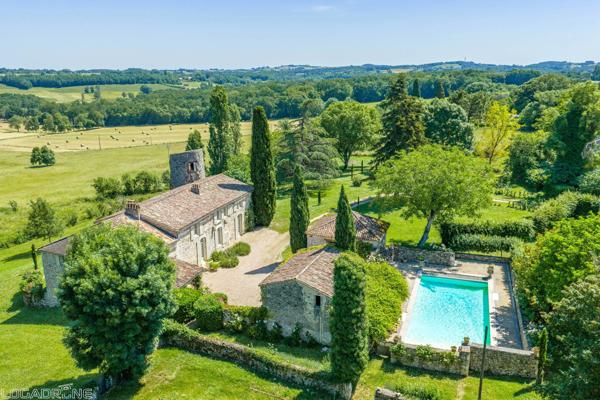 Domaine historique avec piscine, verger et vues sur la campagne environnante.