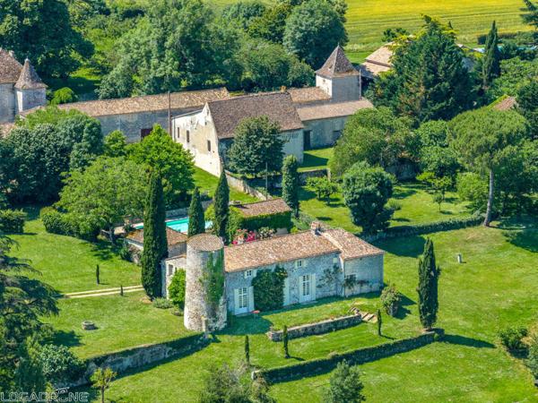 Domaine historique avec piscine, verger et vues sur la campagne environnante.