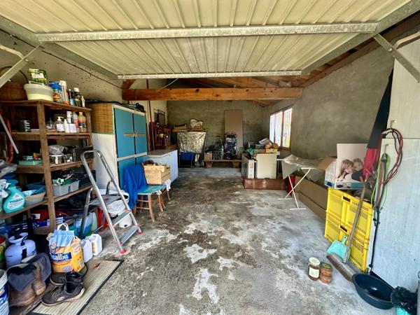 Maison des années 1970 d'environ 92m² avec garage sur un terrain entièrement clos de 1700m² avec puit.