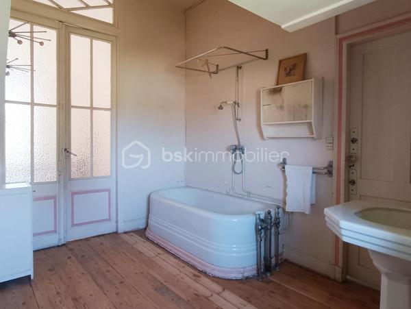 Lectoure séduit par son patrimoine historique, ses thermes réputés, sa vie culturelle dynamique et sa douceur de vivre unique au cœur du Gers.

À quelques pas des commerces, restaurants, écoles, services et du célèbre marché de la ville, cette remarquable demeure de caractère a tout pour devenir une véritable maison de rêve à Lectoure.

Cette maison de ville aux volumes exceptionnels offre de belles hauteurs sous plafond et de nombreux éléments anciens soigneusement préservés : parquets d’époque, moulures, cheminées anciennes…

Traversante sud/nord, la maison bénéficie d’une luminosité remarquable tout au long de la journée. Son grand jardin, avec de superbes vues dégagées sur la campagne, ainsi que sa localisation idéale, en font un bien rare.

Au rez-de-chaussée, une vaste entrée distribue plusieurs pièces aux multiples possibilités d’aménagement : création d’un grand salon de réception, d’une cuisine familiale, accès direct au garage… Un magnifique escalier en pierre mène au jardin.

Depuis l’intérieur, on accède également à la cave, où il serait tout à fait envisageable d’aménager une cuisine d’été ouvrant directement sur le jardin.

Le premier étage accueille de nombreuses pièces de vie laissant libre cours à l’imagination selon vos envies et votre projet. Ce niveau comprend six pièces au total, dont une ancienne cuisine et une salle de bain.

Au deuxième étage, vous trouverez encore cinq chambres ainsi qu’une salle d’eau.

Les menuiseries anciennes en bois ont été conservées et équipées de double vitrage. Les volets peints sont en très bon état, tandis que les sols ont été poncés et laissés bruts, prêts à accueillir votre projet de décoration.

Véritable page blanche pleine de caractère, cette propriété offre un potentiel exceptionnel pour donner vie à un projet familial, artistique, professionnel — ou à une combinaison de tous ces univers. Ses volumes généreux et son charme authentique permettent d’imaginer de nombreuses possibilités.