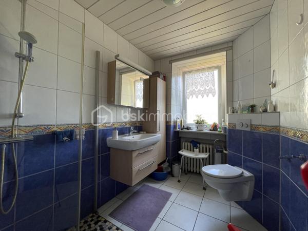 À découvrir dans le quartier très apprécié de Welferding à Sarreguemines, cet ensemble immobilier de caractère offre un fort potentiel pour une famille, un investisseur ou un professionnel souhaitant allier habitation et activité.

Édifié sur un terrain de 32 ares, ce bien développe environ 275 m² habitables ainsi que de vastes espaces de stockage et de stationnement.

Des volumes généreux.
Rez-de-chaussée :
• Trois garages pour une superficie totale d’environ 130 m²
• Un garage supplémentaire d’environ 60 m², situé sous la terrasse
Ces espaces sont parfaitement adaptés à une activité artisanale, du stockage, un atelier ou peuvent être repensés dans le cadre d’un projet immobilier.
Premier étage :
• Appartement lumineux d’environ 155 m²
• Belle terrasse de 60 m², idéale pour profiter des beaux jours
Combles aménagés :
• Appartement d’environ 120 m², offrant de nombreuses possibilités d’aménagement.

Caractéristiques
• Chauffage au gaz
• Fosse septique
• Grande terrasse de 60 m²
• Nombreuses places de stationnement grâce aux garages

Un bien aux multiples possibilités
Cette propriété conviendra parfaitement pour :
• une grande résidence familiale,
• un projet de division en plusieurs appartements destinés à la location,
• une activité professionnelle ou artisanale avec bureaux et stockage,
• un investissement patrimonial à fort potentiel.

Travaux à prévoir
Des travaux de rénovation sont à envisager :
• mise aux normes de l’installation électrique,
• amélioration de l’isolation thermique,
• rafraîchissement général des pièces.

Le terrain de 32 ares, principalement en pente, offre un environnement agréable mais reste peu exploitable.

Une opportunité rare sur le secteur. Contactez-moi pour plus de renseignements ou pour organiser une visite