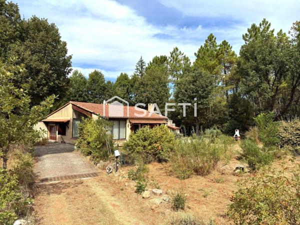 Maison avec véranda sur grand terrain boisé au calme.
