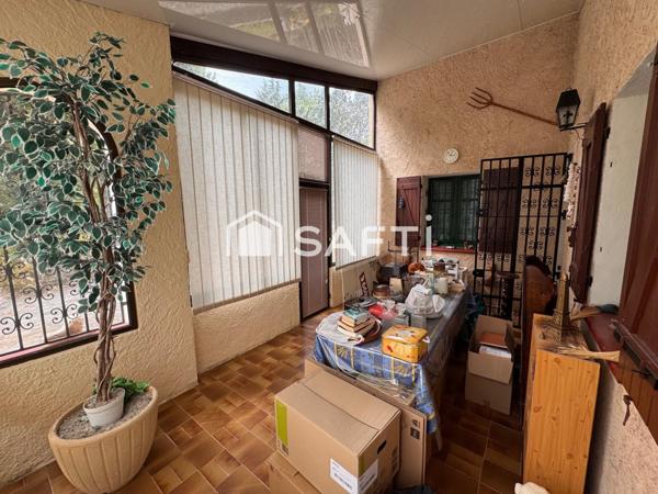 Maison avec véranda sur grand terrain boisé au calme.