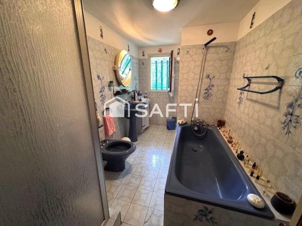 Maison avec véranda sur grand terrain boisé au calme.