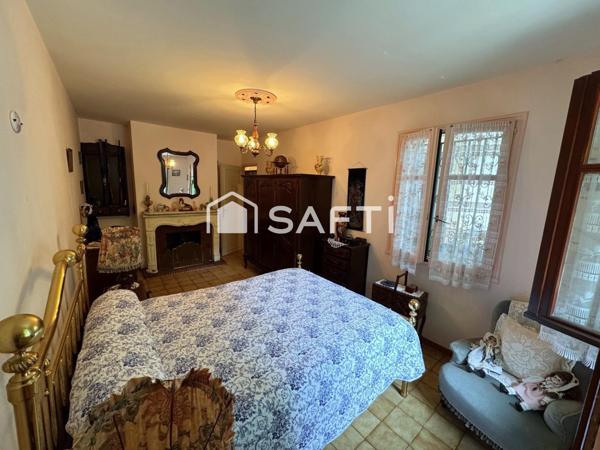 Maison avec véranda sur grand terrain boisé au calme.