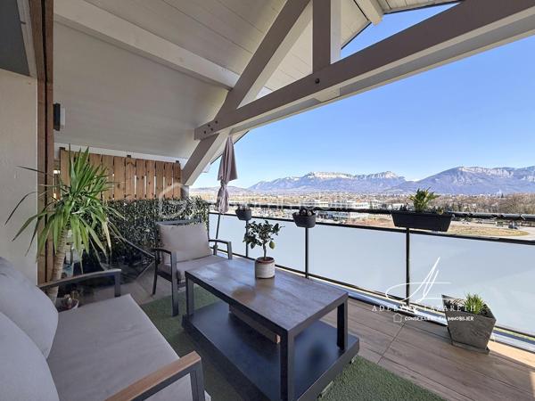 En EXCLUSIVITÉ, sur la commune prisée de Poisy, à proximité immédiate d’Annecy, venez découvrir ce superbe appartement Type 5 de 115 m2 au sol, avec ses volumes généreux, il est idéal pour une famille en quête de confort, de luminosité et de fonctionnalité.

Vous serez séduit par sa pièce de vie baignée de lumière grâce à son exposition plein sud et son plafond cathédrale qui apporte du caractère et une vraie sensation d’espace. Sa cuisine ouverte, entièrement équipée, offre un espace convivial et chaleureux. Ce séjour s’ouvre sur une grande terrasse abritée avec une magnifique vue panoramique sur les montagnes.

L’espace nuit se compose de 3 chambres avec placards de rangement intégrés, et une belle suite parentale disposant de sa salle d’eau privative et de son grand balcon. Une salle de bain supplémentaire ainsi que deux WC (dont un indépendant) complètent ce bien pour un confort optimal au quotidien.

L’appartement bénéficie également de nombreux rangements : placards intégrés, espaces optimisés et volumes bien pensés.

Très lumineux, parfaitement agencé et offrant de belles prestations, ce bien rare allie confort, espace et qualité de vie dans un environnement recherché.

En annexes :
•	Une cave
•	Une place de parking couverte
•	Et possibilité d’acquérir un grand garage en supplément

A proximité des petits commerces, de la Zone commerciale d’Epagny, et à seulement 5 min d’entrée d’autoroute direction Genève. 

À découvrir sans tarder ! N’hésitez pas à me contacter pour organiser une visite.