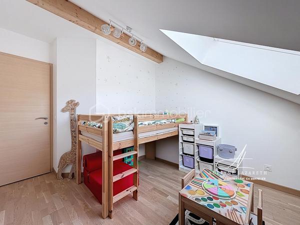 En EXCLUSIVITÉ, sur la commune prisée de Poisy, à proximité immédiate d’Annecy, venez découvrir ce superbe appartement Type 5 de 115 m2 au sol, avec ses volumes généreux, il est idéal pour une famille en quête de confort, de luminosité et de fonctionnalité.

Vous serez séduit par sa pièce de vie baignée de lumière grâce à son exposition plein sud et son plafond cathédrale qui apporte du caractère et une vraie sensation d’espace. Sa cuisine ouverte, entièrement équipée, offre un espace convivial et chaleureux. Ce séjour s’ouvre sur une grande terrasse abritée avec une magnifique vue panoramique sur les montagnes.

L’espace nuit se compose de 3 chambres avec placards de rangement intégrés, et une belle suite parentale disposant de sa salle d’eau privative et de son grand balcon. Une salle de bain supplémentaire ainsi que deux WC (dont un indépendant) complètent ce bien pour un confort optimal au quotidien.

L’appartement bénéficie également de nombreux rangements : placards intégrés, espaces optimisés et volumes bien pensés.

Très lumineux, parfaitement agencé et offrant de belles prestations, ce bien rare allie confort, espace et qualité de vie dans un environnement recherché.

En annexes :
•	Une cave
•	Une place de parking couverte
•	Et possibilité d’acquérir un grand garage en supplément

A proximité des petits commerces, de la Zone commerciale d’Epagny, et à seulement 5 min d’entrée d’autoroute direction Genève. 

À découvrir sans tarder ! N’hésitez pas à me contacter pour organiser une visite.