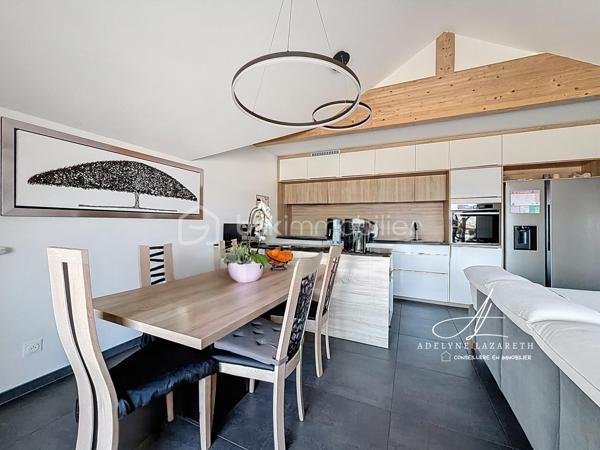 En EXCLUSIVITÉ, sur la commune prisée de Poisy, à proximité immédiate d’Annecy, venez découvrir ce superbe appartement Type 5 de 115 m2 au sol, avec ses volumes généreux, il est idéal pour une famille en quête de confort, de luminosité et de fonctionnalité.

Vous serez séduit par sa pièce de vie baignée de lumière grâce à son exposition plein sud et son plafond cathédrale qui apporte du caractère et une vraie sensation d’espace. Sa cuisine ouverte, entièrement équipée, offre un espace convivial et chaleureux. Ce séjour s’ouvre sur une grande terrasse abritée avec une magnifique vue panoramique sur les montagnes.

L’espace nuit se compose de 3 chambres avec placards de rangement intégrés, et une belle suite parentale disposant de sa salle d’eau privative et de son grand balcon. Une salle de bain supplémentaire ainsi que deux WC (dont un indépendant) complètent ce bien pour un confort optimal au quotidien.

L’appartement bénéficie également de nombreux rangements : placards intégrés, espaces optimisés et volumes bien pensés.

Très lumineux, parfaitement agencé et offrant de belles prestations, ce bien rare allie confort, espace et qualité de vie dans un environnement recherché.

En annexes :
•	Une cave
•	Une place de parking couverte
•	Et possibilité d’acquérir un grand garage en supplément

A proximité des petits commerces, de la Zone commerciale d’Epagny, et à seulement 5 min d’entrée d’autoroute direction Genève. 

À découvrir sans tarder ! N’hésitez pas à me contacter pour organiser une visite.