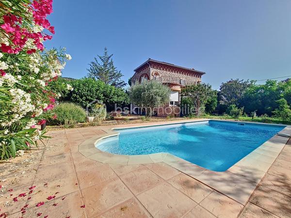 Maison de maître 4 faces avec jardin et vue Canigou dans Prades. sur une grande parcelle de 1750 m²

Cette maison de maître propose une belle pièce de vie traversante prolongée par un espace salon boudoir avec vue jardin, ainsi qu’une véranda permettant de profiter de la vue sur l’extérieur en toute saison.
Elle comprend cinq chambres, dont certaines avec accès direct à une terrasse exposée sud. Les sols en bois massif et les hauteurs sous plafond rappellent le charme et l’architecture d’origine.
Le chauffage est assuré par un poêle à bois et un système central avec radiateurs en fonte
 Une cave et un local chaufferie sont accessibles depuis la cuisine.

Implantée sur un terrain arboré de 1 760 m², sa piscine couverte (9x4 m) avec espace terrasse, barbecue complètent les extérieurs.

Une dépendance permet d’aménager une petite location ,un atelier, un bureau ou un espace d’appoint.

Le bien se situe dans un secteur résidentiel recherché de Prades, à proximité des commodités et des établissements scolaires, tout en restant au calme.