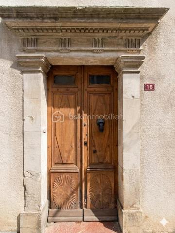 Au coeur du centre bourg de La Bastide-de-Sérou, découvrez une demeure de caractère imprégnée d’un récit hors du commun. Cette maison
n’est pas qu’une simple bâtisse : elle fut le siège d'une étude notariale emblématique. Son histoire raconte l'histoire de la première femme
notaire de France, qui, suite au décès brutal de son père, reprit le flambeau et l'étude familiale avec détermination. Aujourd'hui, cette demeure
chargée d'histoire n'attend que votre vision pour retrouver son lustre d'antan.

La Demeure
Érigée en 1850, cette maison de village mitoyenne développe environ 216 m² habitables répartis sur trois niveaux, offrant de beaux volumes
et le charme authentique des constructions du XIXe siècle.
Rez-de-chaussée : L'entrée, autrefois lieu d'accueil de l'étude, dessert un salon, une cuisine, une salle de bain et des toilettes. Ce niveau
comprend également une chaufferie et offre un accès direct à une véranda de 17 m², véritable trait d'union vers votre futur jardin.
Premier étage : Un palier vestibule distribue trois chambres, dont une suite avec salle de bain, ainsi qu'une pièce dédiée au dressing. Vous
profiterez d'un accès privilégié à un toit-terrasse d'environ 18 m², idéal pour vos moments de quiétude.
Deuxième étage : Le charme des combles et des volumes atypiques. Cet étage comprend un palier, une chambre avec sa cheminée
d'époque (17 m²), une pièce annexe de 6 m², ainsi que deux grands greniers totalisant 54 m² offrant un potentiel d'aménagement
spectaculaire.

Extérieur
Le bien dispose d'un terrain privatif d'environ 200 m², une rareté au coeur d'un centre bourg. Un espace extérieur intime, propice à la création
d'un jardin paysager à votre image.

Située dans une rue calme, cette propriété bénéficie de la proximité immédiate de toutes les commodités, services et commerces de La
Bastide-de-Sérou. Un emplacement stratégique alliant vie de village et accès facilité.

Le Projet
Cette maison de prestige nécessite une rénovation globale (toiture/charpente en bon état). C'est l'opportunité rare de conjuguer une histoire
familiale riche avec un projet de vie sur-mesure, en redonnant vie à des espaces dont les murs ont été les témoins d'un destin exceptionnel.

Amoureux des vieilles pierres, investisseurs ou passionnés d'histoire, venez écrire le prochain chapitre de cette demeure unique.