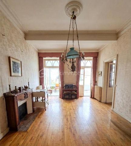 Au coeur du centre bourg de La Bastide-de-Sérou, découvrez une demeure de caractère imprégnée d’un récit hors du commun. Cette maison
n’est pas qu’une simple bâtisse : elle fut le siège d'une étude notariale emblématique. Son histoire raconte l'histoire de la première femme
notaire de France, qui, suite au décès brutal de son père, reprit le flambeau et l'étude familiale avec détermination. Aujourd'hui, cette demeure
chargée d'histoire n'attend que votre vision pour retrouver son lustre d'antan.

La Demeure
Érigée en 1850, cette maison de village mitoyenne développe environ 216 m² habitables répartis sur trois niveaux, offrant de beaux volumes
et le charme authentique des constructions du XIXe siècle.
Rez-de-chaussée : L'entrée, autrefois lieu d'accueil de l'étude, dessert un salon, une cuisine, une salle de bain et des toilettes. Ce niveau
comprend également une chaufferie et offre un accès direct à une véranda de 17 m², véritable trait d'union vers votre futur jardin.
Premier étage : Un palier vestibule distribue trois chambres, dont une suite avec salle de bain, ainsi qu'une pièce dédiée au dressing. Vous
profiterez d'un accès privilégié à un toit-terrasse d'environ 18 m², idéal pour vos moments de quiétude.
Deuxième étage : Le charme des combles et des volumes atypiques. Cet étage comprend un palier, une chambre avec sa cheminée
d'époque (17 m²), une pièce annexe de 6 m², ainsi que deux grands greniers totalisant 54 m² offrant un potentiel d'aménagement
spectaculaire.

Extérieur
Le bien dispose d'un terrain privatif d'environ 200 m², une rareté au coeur d'un centre bourg. Un espace extérieur intime, propice à la création
d'un jardin paysager à votre image.

Située dans une rue calme, cette propriété bénéficie de la proximité immédiate de toutes les commodités, services et commerces de La
Bastide-de-Sérou. Un emplacement stratégique alliant vie de village et accès facilité.

Le Projet
Cette maison de prestige nécessite une rénovation globale (toiture/charpente en bon état). C'est l'opportunité rare de conjuguer une histoire
familiale riche avec un projet de vie sur-mesure, en redonnant vie à des espaces dont les murs ont été les témoins d'un destin exceptionnel.

Amoureux des vieilles pierres, investisseurs ou passionnés d'histoire, venez écrire le prochain chapitre de cette demeure unique.