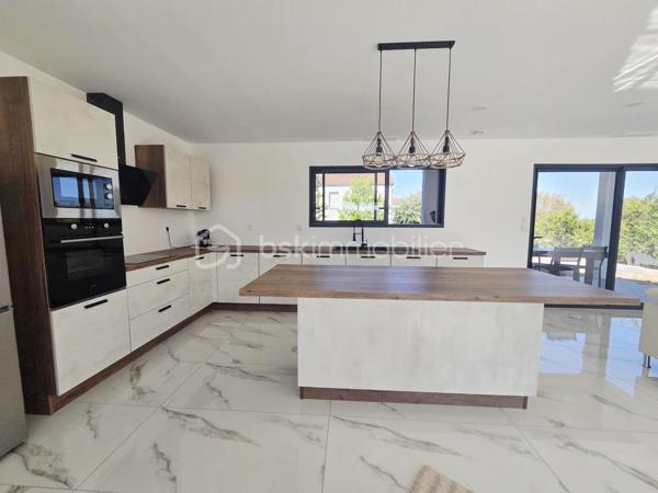 Découvrez cette belle maison contemporaine de plain-pied, offrant des prestations modernes et des espaces pensés pour un quotidien confortable.

✨ Dès l’entrée, vous serez séduits par la luminosité et les volumes de la pièce de vie. Celle-ci accueille une superbe cuisine ouverte entièrement aménagée et équipée, aux lignes contemporaines, avec un généreux îlot central créant un espace convivial idéal pour recevoir famille et amis.

🌿 De larges ouvertures permettent de profiter pleinement de la lumière naturelle et donnent accès à une agréable terrasse couverte, véritable prolongement de la pièce de vie pour profiter des beaux jours.

🛏️ La partie nuit propose des espaces sobres et lumineux, facilement personnalisables selon vos envies. La maison dispose également d’une salle de bains moderne, équipée notamment d’une baignoire et d'un meuble vasque, dans une ambiance élégante et actuelle.
🚗 Un garage attenant complète l'ensemble et apporte un espace supplémentaire appréciable pour le stationnement et le rangement.

À l’extérieur, l’architecture contemporaine, les menuiseries foncées et la toiture en tuiles confèrent à cette maison une allure à la fois moderne et chaleureuse.

❤️ Les atouts :
• Maison de plain-pied
• Construction contemporaine
• Belle luminosité
• Grande pièce de vie
• Cuisine aménagée et équipée avec îlot central
• Terrasse couverte
• Salle de bains moderne
• Garage attenant
• Prestations actuelles et décoration neutre, prête à accueillir ses nouveaux propriétaires