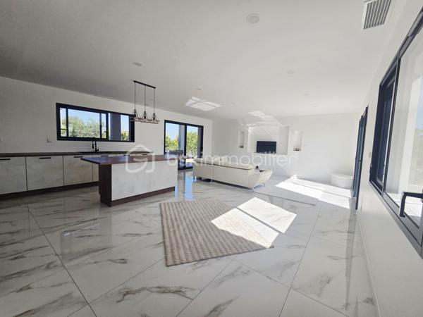 Découvrez cette belle maison contemporaine de plain-pied, offrant des prestations modernes et des espaces pensés pour un quotidien confortable.

✨ Dès l’entrée, vous serez séduits par la luminosité et les volumes de la pièce de vie. Celle-ci accueille une superbe cuisine ouverte entièrement aménagée et équipée, aux lignes contemporaines, avec un généreux îlot central créant un espace convivial idéal pour recevoir famille et amis.

🌿 De larges ouvertures permettent de profiter pleinement de la lumière naturelle et donnent accès à une agréable terrasse couverte, véritable prolongement de la pièce de vie pour profiter des beaux jours.

🛏️ La partie nuit propose des espaces sobres et lumineux, facilement personnalisables selon vos envies. La maison dispose également d’une salle de bains moderne, équipée notamment d’une baignoire et d'un meuble vasque, dans une ambiance élégante et actuelle.
🚗 Un garage attenant complète l'ensemble et apporte un espace supplémentaire appréciable pour le stationnement et le rangement.

À l’extérieur, l’architecture contemporaine, les menuiseries foncées et la toiture en tuiles confèrent à cette maison une allure à la fois moderne et chaleureuse.

❤️ Les atouts :
• Maison de plain-pied
• Construction contemporaine
• Belle luminosité
• Grande pièce de vie
• Cuisine aménagée et équipée avec îlot central
• Terrasse couverte
• Salle de bains moderne
• Garage attenant
• Prestations actuelles et décoration neutre, prête à accueillir ses nouveaux propriétaires