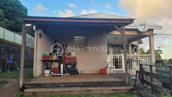 Vente Maison familiale de plain-pied de 97 m² avec terrasse, idéalement située dans le quartier résidentiel des Jacques à Saint-Joseph, proche des écoles et des commodités. Cette maison de plain-pied de 97 m² habitables saura séduire les acquéreurs en quête d'un bien fonctionnel et bien agencé, que ce soit pour y établir leur résidence principale ou pour réaliser un investissement locatif. 

Implantée dans un environnement calme et agréable, cette propriété bénéficie d'une bonne exposition et d'une construction solide en dur, avec toiture tôle et chauffe-eau solaire.

Dès l'entrée, d'une superficie de 3,60 m², vous accédez à la cuisine et l'espace de distribution bien pensé qui dessert l'ensemble des pièces de vie et des chambres. 

Le salon, vaste et lumineux, offre une superficie de 24,80 m². Il bénéficie d'une belle hauteur sous plafond et d'un accès direct sur la terrasse extérieure par l'intermédiaire d'une baie vitrée coulissante. L'espace de vie est prolongé par un hall terrasse de 9,40 m², créant une continuité agréable entre l'intérieur et l'extérieur, idéal pour profiter du cadre réunionnais tout au long de l'année. 

La cuisine, d'une superficie de 14,40 m² dispose d'une implantation en L avec de nombreux meubles de rangement, d'une plaque de cuisson, d'une hotte aspirante, et est dotée de fenêtres à jalousies garantissant une ventilation naturelle optimale. Fonctionnelle et agréable, elle conviendra parfaitement aux familles. 

Le couloir de 5 m² dessert les trois chambres, la salle de bain et le WC indépendant. Les trois chambres sont dotées de fenêtres assurant un bon renouvellement de l'air, présentent des superficies généreuses et confortables :

Chambre 1 : 12,20 m²
Chambre 2 : 10,40 m²
Chambre 3 : 11 m²

La salle de bain de 4,40 m² est équipée d'une baignoire d'angle, d'une vasque encastrée et d'un miroir. Elle dispose d'une fenêtre permettant une aération naturelle. Le WC, séparé de la salle de bain, offre une superficie de 1,80 m².

L'extérieur de la propriété constitue un véritable atout supplémentaire. La maison dispose d'une terrasse couverte de 16 m², parfaitement adaptée aux repas en plein air et aux moments de convivialité en famille ou entre amis. 

Une terrasse couvert supplémentaire aménagée avec une structure en bois et une toiture en tôle, accessible depuis l'extérieur, offre un espace de rangement. Le terrain entourant la maison dispose d'espaces verts, apportant une note de verdure et de sérénité à l'ensemble. 

La maison est implantée sur un terrain d'une superficie de 465 m², offrant un espace extérieur agréable autour de la maison. Concernant l'assainissement, la maison est équipée d'une fosse septique. 

Informations locatives
Ce bien est proposé à la vente et est actuellement occupé. Il est loué dans le cadre d'un bail d'habitation nu, avec des locataires en place jusqu'au 31 janvier 2027.

Le loyer mensuel en cours s'élève à 768 euros hors charges. Cette configuration permet à l'acquéreur de percevoir des revenus locatifs dès la signature de l'acte authentique, tout en se constituant un patrimoine immobilier dans un secteur résidentiel de Saint-Joseph.

Pour organiser une visite ou obtenir des informations complémentaires, contactez-moi.