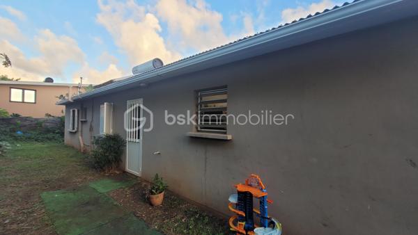 Vente Maison familiale de plain-pied de 97 m² avec terrasse, idéalement située dans le quartier résidentiel des Jacques à Saint-Joseph, proche des écoles et des commodités. Cette maison de plain-pied de 97 m² habitables saura séduire les acquéreurs en quête d'un bien fonctionnel et bien agencé, que ce soit pour y établir leur résidence principale ou pour réaliser un investissement locatif. 

Implantée dans un environnement calme et agréable, cette propriété bénéficie d'une bonne exposition et d'une construction solide en dur, avec toiture tôle et chauffe-eau solaire.

Dès l'entrée, d'une superficie de 3,60 m², vous accédez à la cuisine et l'espace de distribution bien pensé qui dessert l'ensemble des pièces de vie et des chambres. 

Le salon, vaste et lumineux, offre une superficie de 24,80 m². Il bénéficie d'une belle hauteur sous plafond et d'un accès direct sur la terrasse extérieure par l'intermédiaire d'une baie vitrée coulissante. L'espace de vie est prolongé par un hall terrasse de 9,40 m², créant une continuité agréable entre l'intérieur et l'extérieur, idéal pour profiter du cadre réunionnais tout au long de l'année. 

La cuisine, d'une superficie de 14,40 m² dispose d'une implantation en L avec de nombreux meubles de rangement, d'une plaque de cuisson, d'une hotte aspirante, et est dotée de fenêtres à jalousies garantissant une ventilation naturelle optimale. Fonctionnelle et agréable, elle conviendra parfaitement aux familles. 

Le couloir de 5 m² dessert les trois chambres, la salle de bain et le WC indépendant. Les trois chambres sont dotées de fenêtres assurant un bon renouvellement de l'air, présentent des superficies généreuses et confortables :

Chambre 1 : 12,20 m²
Chambre 2 : 10,40 m²
Chambre 3 : 11 m²

La salle de bain de 4,40 m² est équipée d'une baignoire d'angle, d'une vasque encastrée et d'un miroir. Elle dispose d'une fenêtre permettant une aération naturelle. Le WC, séparé de la salle de bain, offre une superficie de 1,80 m².

L'extérieur de la propriété constitue un véritable atout supplémentaire. La maison dispose d'une terrasse couverte de 16 m², parfaitement adaptée aux repas en plein air et aux moments de convivialité en famille ou entre amis. 

Une terrasse couvert supplémentaire aménagée avec une structure en bois et une toiture en tôle, accessible depuis l'extérieur, offre un espace de rangement. Le terrain entourant la maison dispose d'espaces verts, apportant une note de verdure et de sérénité à l'ensemble. 

La maison est implantée sur un terrain d'une superficie de 465 m², offrant un espace extérieur agréable autour de la maison. Concernant l'assainissement, la maison est équipée d'une fosse septique. 

Informations locatives
Ce bien est proposé à la vente et est actuellement occupé. Il est loué dans le cadre d'un bail d'habitation nu, avec des locataires en place jusqu'au 31 janvier 2027.

Le loyer mensuel en cours s'élève à 768 euros hors charges. Cette configuration permet à l'acquéreur de percevoir des revenus locatifs dès la signature de l'acte authentique, tout en se constituant un patrimoine immobilier dans un secteur résidentiel de Saint-Joseph.

Pour organiser une visite ou obtenir des informations complémentaires, contactez-moi.