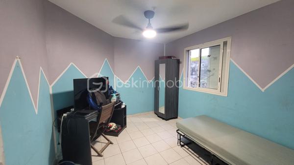 Vente Maison familiale de plain-pied de 97 m² avec terrasse, idéalement située dans le quartier résidentiel des Jacques à Saint-Joseph, proche des écoles et des commodités. Cette maison de plain-pied de 97 m² habitables saura séduire les acquéreurs en quête d'un bien fonctionnel et bien agencé, que ce soit pour y établir leur résidence principale ou pour réaliser un investissement locatif. 

Implantée dans un environnement calme et agréable, cette propriété bénéficie d'une bonne exposition et d'une construction solide en dur, avec toiture tôle et chauffe-eau solaire.

Dès l'entrée, d'une superficie de 3,60 m², vous accédez à la cuisine et l'espace de distribution bien pensé qui dessert l'ensemble des pièces de vie et des chambres. 

Le salon, vaste et lumineux, offre une superficie de 24,80 m². Il bénéficie d'une belle hauteur sous plafond et d'un accès direct sur la terrasse extérieure par l'intermédiaire d'une baie vitrée coulissante. L'espace de vie est prolongé par un hall terrasse de 9,40 m², créant une continuité agréable entre l'intérieur et l'extérieur, idéal pour profiter du cadre réunionnais tout au long de l'année. 

La cuisine, d'une superficie de 14,40 m² dispose d'une implantation en L avec de nombreux meubles de rangement, d'une plaque de cuisson, d'une hotte aspirante, et est dotée de fenêtres à jalousies garantissant une ventilation naturelle optimale. Fonctionnelle et agréable, elle conviendra parfaitement aux familles. 

Le couloir de 5 m² dessert les trois chambres, la salle de bain et le WC indépendant. Les trois chambres sont dotées de fenêtres assurant un bon renouvellement de l'air, présentent des superficies généreuses et confortables :

Chambre 1 : 12,20 m²
Chambre 2 : 10,40 m²
Chambre 3 : 11 m²

La salle de bain de 4,40 m² est équipée d'une baignoire d'angle, d'une vasque encastrée et d'un miroir. Elle dispose d'une fenêtre permettant une aération naturelle. Le WC, séparé de la salle de bain, offre une superficie de 1,80 m².

L'extérieur de la propriété constitue un véritable atout supplémentaire. La maison dispose d'une terrasse couverte de 16 m², parfaitement adaptée aux repas en plein air et aux moments de convivialité en famille ou entre amis. 

Une terrasse couvert supplémentaire aménagée avec une structure en bois et une toiture en tôle, accessible depuis l'extérieur, offre un espace de rangement. Le terrain entourant la maison dispose d'espaces verts, apportant une note de verdure et de sérénité à l'ensemble. 

La maison est implantée sur un terrain d'une superficie de 465 m², offrant un espace extérieur agréable autour de la maison. Concernant l'assainissement, la maison est équipée d'une fosse septique. 

Informations locatives
Ce bien est proposé à la vente et est actuellement occupé. Il est loué dans le cadre d'un bail d'habitation nu, avec des locataires en place jusqu'au 31 janvier 2027.

Le loyer mensuel en cours s'élève à 768 euros hors charges. Cette configuration permet à l'acquéreur de percevoir des revenus locatifs dès la signature de l'acte authentique, tout en se constituant un patrimoine immobilier dans un secteur résidentiel de Saint-Joseph.

Pour organiser une visite ou obtenir des informations complémentaires, contactez-moi.