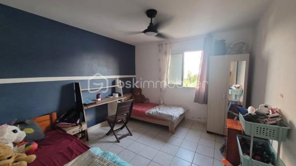 Vente Maison familiale de plain-pied de 97 m² avec terrasse, idéalement située dans le quartier résidentiel des Jacques à Saint-Joseph, proche des écoles et des commodités. Cette maison de plain-pied de 97 m² habitables saura séduire les acquéreurs en quête d'un bien fonctionnel et bien agencé, que ce soit pour y établir leur résidence principale ou pour réaliser un investissement locatif. 

Implantée dans un environnement calme et agréable, cette propriété bénéficie d'une bonne exposition et d'une construction solide en dur, avec toiture tôle et chauffe-eau solaire.

Dès l'entrée, d'une superficie de 3,60 m², vous accédez à la cuisine et l'espace de distribution bien pensé qui dessert l'ensemble des pièces de vie et des chambres. 

Le salon, vaste et lumineux, offre une superficie de 24,80 m². Il bénéficie d'une belle hauteur sous plafond et d'un accès direct sur la terrasse extérieure par l'intermédiaire d'une baie vitrée coulissante. L'espace de vie est prolongé par un hall terrasse de 9,40 m², créant une continuité agréable entre l'intérieur et l'extérieur, idéal pour profiter du cadre réunionnais tout au long de l'année. 

La cuisine, d'une superficie de 14,40 m² dispose d'une implantation en L avec de nombreux meubles de rangement, d'une plaque de cuisson, d'une hotte aspirante, et est dotée de fenêtres à jalousies garantissant une ventilation naturelle optimale. Fonctionnelle et agréable, elle conviendra parfaitement aux familles. 

Le couloir de 5 m² dessert les trois chambres, la salle de bain et le WC indépendant. Les trois chambres sont dotées de fenêtres assurant un bon renouvellement de l'air, présentent des superficies généreuses et confortables :

Chambre 1 : 12,20 m²
Chambre 2 : 10,40 m²
Chambre 3 : 11 m²

La salle de bain de 4,40 m² est équipée d'une baignoire d'angle, d'une vasque encastrée et d'un miroir. Elle dispose d'une fenêtre permettant une aération naturelle. Le WC, séparé de la salle de bain, offre une superficie de 1,80 m².

L'extérieur de la propriété constitue un véritable atout supplémentaire. La maison dispose d'une terrasse couverte de 16 m², parfaitement adaptée aux repas en plein air et aux moments de convivialité en famille ou entre amis. 

Une terrasse couvert supplémentaire aménagée avec une structure en bois et une toiture en tôle, accessible depuis l'extérieur, offre un espace de rangement. Le terrain entourant la maison dispose d'espaces verts, apportant une note de verdure et de sérénité à l'ensemble. 

La maison est implantée sur un terrain d'une superficie de 465 m², offrant un espace extérieur agréable autour de la maison. Concernant l'assainissement, la maison est équipée d'une fosse septique. 

Informations locatives
Ce bien est proposé à la vente et est actuellement occupé. Il est loué dans le cadre d'un bail d'habitation nu, avec des locataires en place jusqu'au 31 janvier 2027.

Le loyer mensuel en cours s'élève à 768 euros hors charges. Cette configuration permet à l'acquéreur de percevoir des revenus locatifs dès la signature de l'acte authentique, tout en se constituant un patrimoine immobilier dans un secteur résidentiel de Saint-Joseph.

Pour organiser une visite ou obtenir des informations complémentaires, contactez-moi.