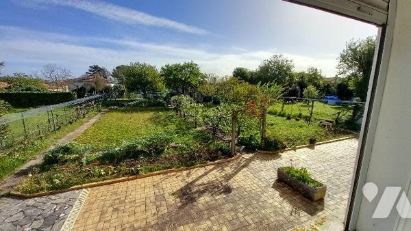 Maison de ville a étage avec un grand jardin arboré.