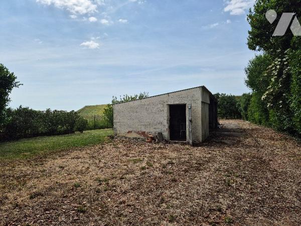 A Mouzeuil St Martin, garage de 15 m² et abri de 120 m² sur terrain de loisirs de 832 m² avec eau.