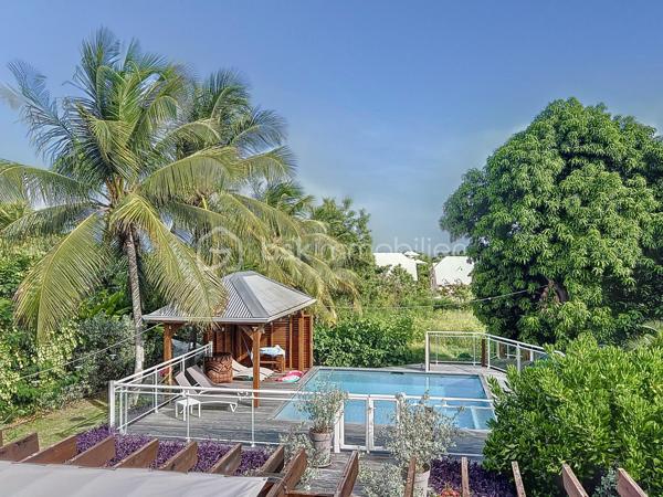 Delphine MIRANDA pour BSK Immobilier 

Un véritable écrin de sérénité à quelques minutes du bourg et des plages de Saint François.
Découvrez ce magnifique appartement T3 de 68 m2 (surface Carrez) offrant 125 m2 de surface totale , situé en rez-de-jardin d'une villa de standing au sein d'une petite copropriété de 4 lots.

Dès l'entrée vous serez séduit par sa décoration élégante et soignée, ses volumes agréables et son atmosphère chaleureuse.
L'appartement se compose d'une entrée, d'une cuisine aménagée et entièrement équipée ouverte sur un lumineux espace de vie, de deux chambres climatisée, dont l'une bénéficie d'un accès direct à la terrasse, ainsi que d'une salle d'eau avec douche et wc.

Les extérieurs sont pensés pour profiter pleinement de la vie antillaise :  le véritable coup de coeur réside dans ses beaux espaces privatifs, parfaitement intégrés à un environnement tropical luxuriant.
Vous profitez d'une terrasse couverte aménagée de 21 m2 prolongée par un deck de 32 m2 sous pergola, offrant une agréable perspective sur le jardin paysager et permettant de rejoindre directement la piscine.
Au coeur de cette végétation généreuse, la propriété dispose d'une piscine au sel de 5 x 5,50 m avec son solarium , accompagné d'une douche extérieure et d'un carbet détente idéal pour créer un espace supplémentaire dédié au repos et aux loisirs.
Le jardin soigneusement paysagé, accueille une belle diversité créant une ambiance intimiste et particulièrement apaisante.

Les prestations qui font la différence : 

- appartement vendu meublé clé en main 
- 68 m2 Carrez 125 m2 de surface totale 
- terrasse couverte de 21 m2
- deck de 32 m2 sous pergola 
- piscine au sel avec solarium et douche extérieure 
- jardin tropical paysager
- une place de stationnement privative 
- citerne tampon pour pallier aux coupures d'eau 
- chauffe-eau solaire 
- petite copropriété de 4 lots 
- DPE G / étiquette énergétique classe A 

Situé dans un secteur résidentiel calme et recherché tout en restant proche du bourg de Saint François, des commerces et des magnifiques plages de la commune, cet appartement constitue une adresse idéale aussi bien pour une résidence principale que pour une résidence secondaire ou un investissement locatif.

Un bien rare alliant confort, élégance et douceur de vivre tropicale, dans un environnement privilégié.
A découvrir sans tarder ! 

Pour plus d'informations, merci de privilégier l'appel ou sms whatsapp , demandez la vidéo ou positionner une visite.