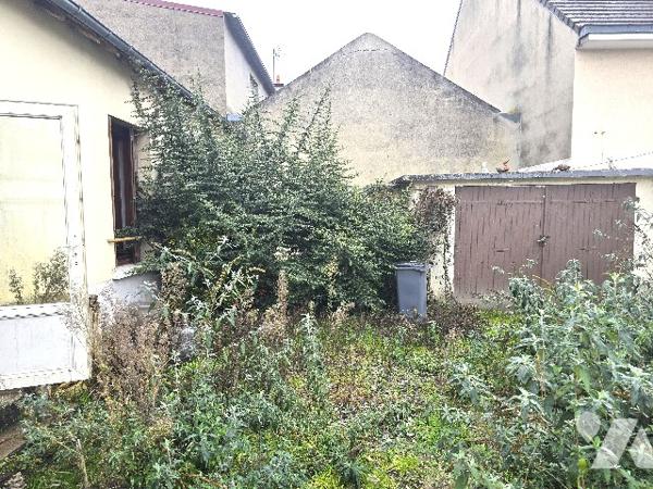 Maison de ville avec jardinet et garage.