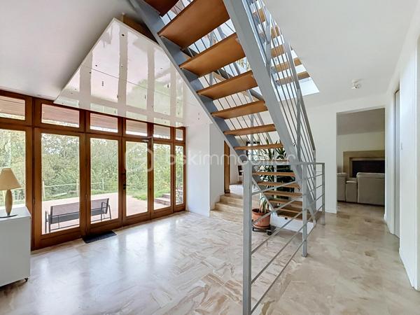 Coup de cœur assuré pour cette sublime maison d'architecte de 215 m² qui allie à la perfection volumes d'exception, sérénité et confort moderne (DPE C). 
Nichée sur une magnifique parcelle, en partie boisée, d'environ 5000 m2 à deux pas du centre-ville et de toutes ses commodités, elle offre une atmosphère apaisante unique !

Dès son entrée spacieuse , vous serez charmés par la clarté et la fluidité des espaces du rez de chaussée , composé d'un vaste salon de 35 m², d'un séjour-cuisine convivial de 35 m², ainsi que d'une salle d'eau, d'un WC et d'un cellier.

L'architecture atypique de la maison se dévoile à travers ses mezzanines à chaque niveau. Le premier étage propose trois belles chambres, dont une avec un grand dressing, une salle de bains et l'accès à une terrasse confortable surplombant la nature environnante. 

Enfin, le dernier niveau révèle une spectaculaire mezzanine vitrée, véritable puits de lumière naturelle, qui dessert deux chambres supplémentaires. 

Une demeure chaleureuse et lumineuse, idéale pour partager de précieux moments en famille tout en préservant l'intimité de chacun.